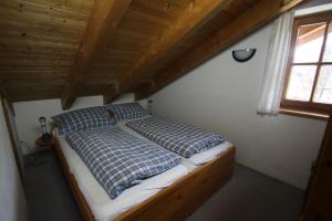 Ce lit se trouve dans une chambre dotée d'un plafond en bois. dans l'établissement Ferienwohnung Almhüttenweg Dreitorspitze, à Garmisch-Partenkirchen
