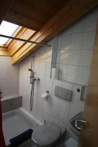 une salle de bain avec toilettes, baignoire et lavabo dans l'établissement Ferienwohnung Almhüttenweg Dreitorspitze, à Garmisch-Partenkirchen