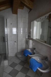 een badkamer met een wastafel, een toilet en een spiegel bij Ferienwohnung Almhüttenweg Dreitorspitze in Garmisch-Partenkirchen