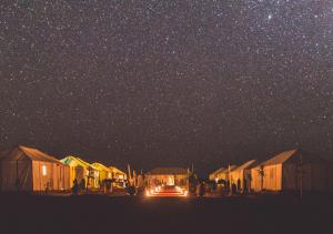 a starry night with a car under a cluster of huts at Amazing Luxury Camp in Merzouga