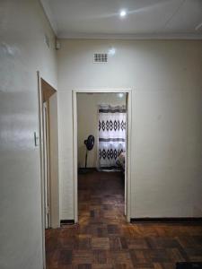 een lege kamer met een gang met een deur naar een slaapkamer bij Stay Sunrise in Nelspruit