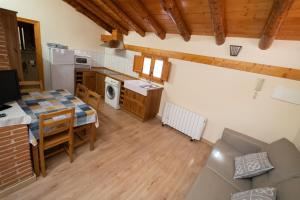 a kitchen and dining room with a table and a couch at Apartamentos la Rambla Solanar in Montalbán