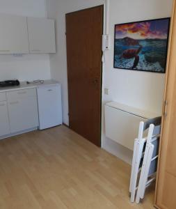 a kitchen with a refrigerator and a table and two chairs at Zimmervermietung Müller in Zeltweg