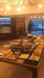 um buffet com muitos tipos diferentes de comida em uma mesa em Hotel Comoditá Ltda em Sapiranga