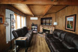 a living room with leather couches and a fireplace at Snow Otter Haus in Bessemer
