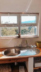 um lavatório numa cozinha com duas janelas em The Annex at Quinta Solar em Vale de Prazeres