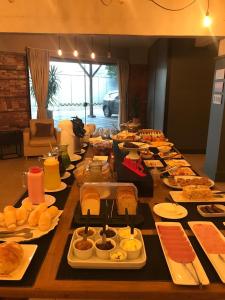 a long table filled with plates of food at Hotel Comoditá Ltda in Sapiranga