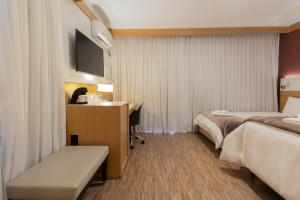 a hotel room with two beds and a desk at BHomy Pinheiros - Flat em ótima região Q1601 in Sao Paulo