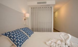 a bedroom with a bed with a swan towel on it at Hotel Rosamar - Emar Hotels in Es Pujols