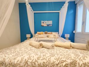 a blue bedroom with a large bed with curtains at Évasion Santorin - Jacuzzi & Relax in Le Havre