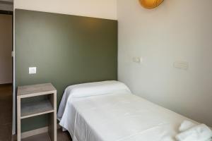 a bedroom with two beds and a green wall at Hostal Alicante in San Antonio