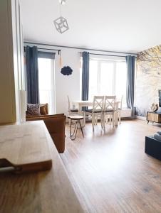 a living room with a table and chairs and windows at Sweet Heart Home in Szczecin