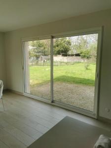 um quarto com uma grande janela com vista para um quintal em Chambres d'hôtes chez Manon em Sampans