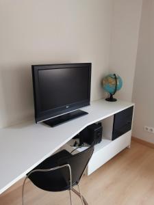 un escritorio blanco con TV encima en Chambres d'hôtes chez Manon, en Sampans