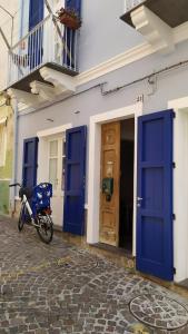 カルロフォルテにあるB&B Terra - Stanza Viaggioの青い扉付きの建物の前に停車するオートバイ