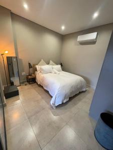 1 dormitorio con 1 cama blanca en una habitación en On Fredman Drive en Johannesburgo