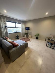 uma sala de estar com um sofá e uma televisão de ecrã plano em On Fredman Drive em Joanesburgo