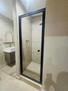 ヨハネスブルグにあるOn Fredman Driveのバスルーム(ガラス張りのシャワー、シンク付)