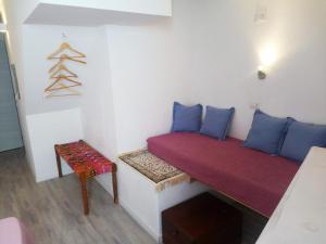 um pequeno quarto com um sofá vermelho e uma cadeira em B&B Terra - Stanza Viaggio em Carloforte