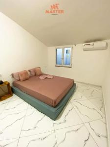 - une chambre avec un lit dans une pièce dotée d'un sol en marbre dans l'établissement App Cidadela, à Praia