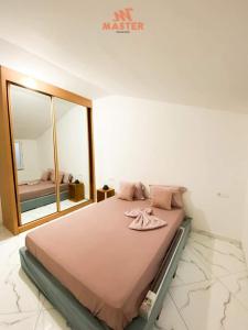 - une chambre avec un grand lit et un miroir dans l'établissement App Cidadela, à Praia
