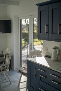 a kitchen with a counter and a table and chairs at Glen Lodge in Ballymoney