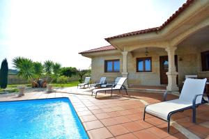 eine Terrasse mit Stühlen und einem Swimmingpool in der Unterkunft GALIHOST - Villa con piscina en Cambados in Cambados
