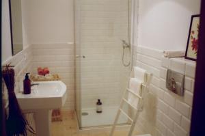 uma casa de banho com um chuveiro e um lavatório. em Poganty - Obora em Giżycko