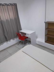 Habitación con escritorio blanco y silla roja. en Aloha Hostel&CoWorking - Prox Aeroporto e Consulado en Porto Alegre