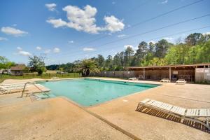 a swimming pool with two lounge chairs in a yard at Biloxi Resort Cottage with Pool and Lake Access! in Biloxi