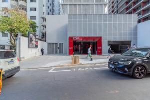 um carro estacionado em frente a um edifício vermelho em BHomy Consolacao Studio completo CN1213 em São Paulo