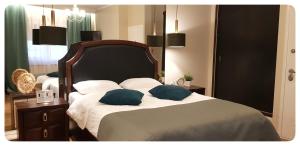 a bedroom with a large bed with blue pillows at Elania Residence in Târgu Jiu