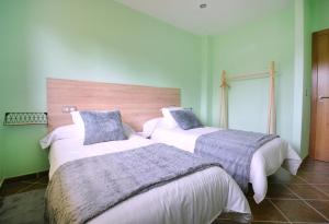 zwei Betten in einem Zimmer mit grünen Wänden in der Unterkunft GALIHOST - Villa con piscina en Cambados in Cambados + 33 Fotos