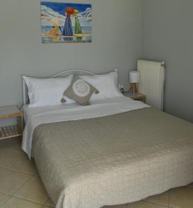 sypialnia z dużym łóżkiem z białą pościelą w obiekcie Natalia guest house w mieście Kawala