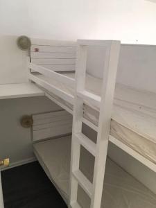 Ce lit superposé blanc se trouve dans un dortoir. dans l'établissement Beau studio plein sud dans résidence tout confort, à Saint-Étienne-en-Dévoluy