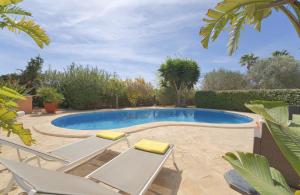 a swimming pool with two lounge chairs next to it at Can Juanito in Playa d'en Bossa