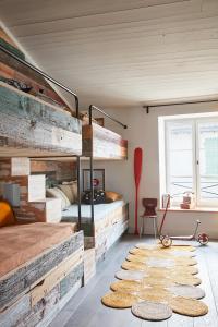 a bedroom with two bunk beds and rugs at Maisons 322 - La Flamboyante in Le Bois-Plage-en-Ré