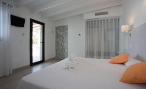 a white bed with a stuffed animal on top of it at Hotel Rosamar - Emar Hotels in Es Pujols