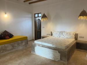 a bedroom with two beds in a room at Mgongo tree house in Jambiani