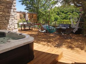a patio with a tub and a table and chairs at Roulotte la clé du Luberon in Buoux