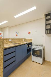 a kitchen with blue cabinets and a sink and a stove at BHomy Paulista Remodelado na Av Paulista BA204 in São Paulo