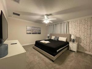 a bedroom with a bed and a ceiling fan at 4BR Townhouse Private Pool BBQ Near Disney in Kissimmee