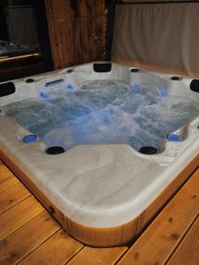 a jacuzzi tub sitting on top of a wooden floor at Chalet le Faye in Waimes