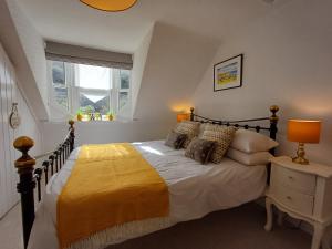 a bedroom with a large bed and a window at Creel Cottage in Cullen