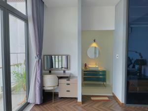 een badkamer met een bureau, een spiegel en een wastafel bij Private 5Brs Pool Villa Luxurious Furniture in Da Nang
