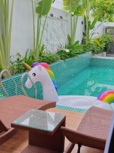 a table with a toy unicorn sitting next to a pool at Private 5Brs Pool Villa Luxurious Furniture in Danang