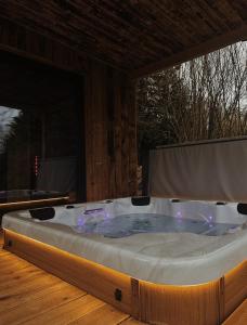 eine Whirlpool-Badewanne auf einem Holzboden in der Unterkunft Chalet le Faye in Weismes