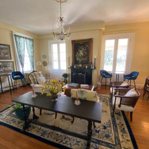 een woonkamer met een tafel en stoelen en een open haard bij The Ocean House in Spring Lake