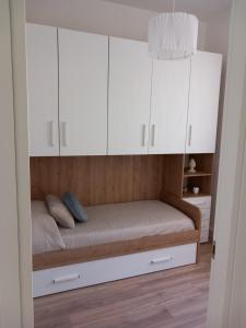 a small bedroom with white cabinets and a bed at La dolce vita casa vacanze in Cisterna di Latina