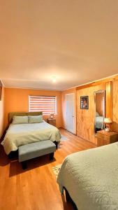 1 dormitorio con 2 camas y TV. en the house of flowers en Osorno